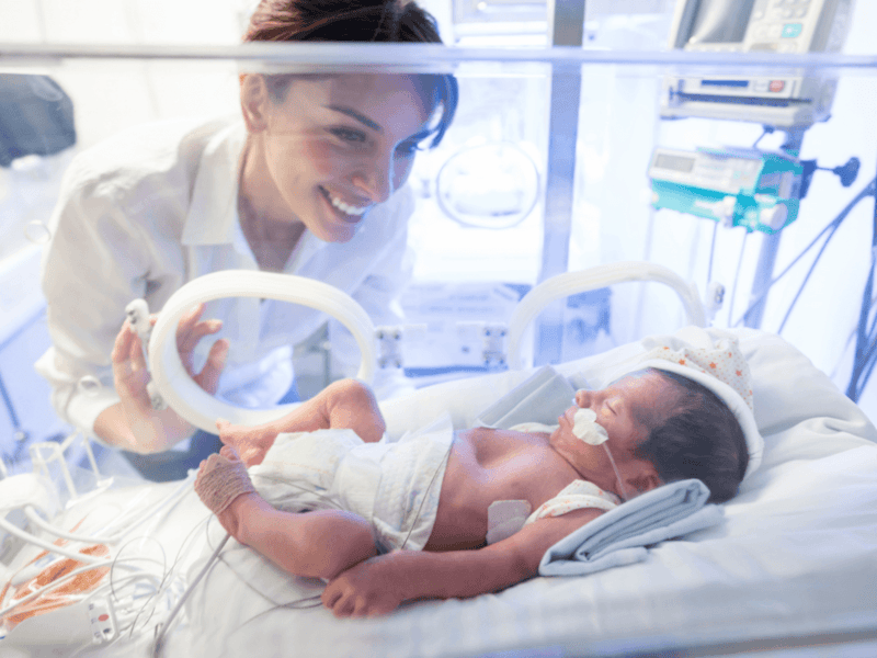 Nurse caring for baby in neonatal ward
